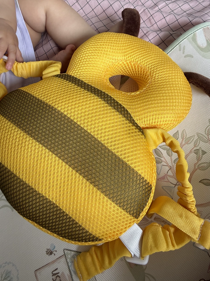 Customer photo showing the Buzzy Bee cushion beside a baby